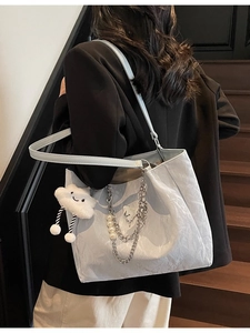 Light blue pleated tote bag with silver chain, pearl strap and cloud charm on model
