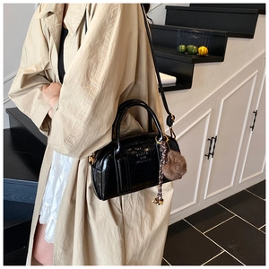 Sac à bandoulière en cuir noir brillant avec gaufrage de lettres et charm en peluche