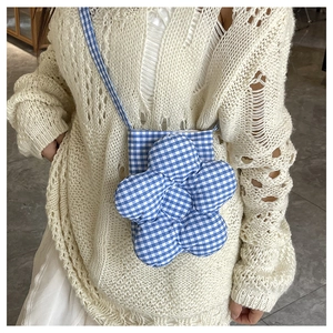 Gros plan du sac bandoulière en forme de fleur à carreaux bleus et blancs sur un mannequin