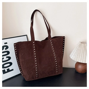 Detail of dark brown suede tote bag featuring vertical silver stud embellishments