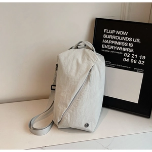 Detail of grey canvas crossbody bag with diagonal zipper pocket and adjustable strap