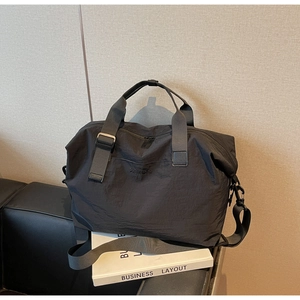 Close-up of black travel bag showing high-density nylon texture and embossed logo