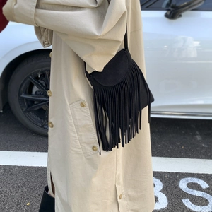 Retro vintage black tassel crossbody bag for women styled with a chic beige trench coat