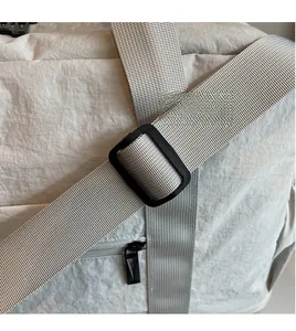 Detail of adjustable wide shoulder strap and durable nylon fabric on travel bag