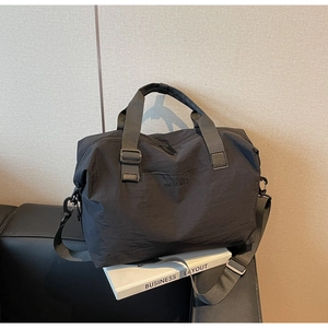 Detail of black waterproof travel bag featuring embossed WeiLiao logo and sturdy strap