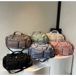 Serie di borse da viaggio in nylon dai colori assortiti su supporti espositivi bianchi