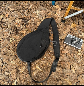 Breathable honeycomb mesh padding on back of black nylon crossbody bag for comfort