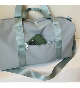 Detailed view of the front zipper pocket on a blue gym bag showing mobile phone storage