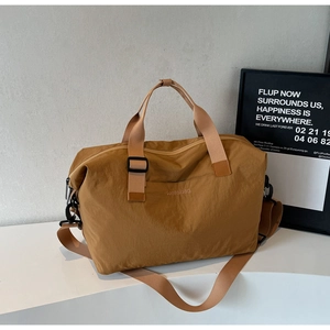 Detail of khaki waterproof travel bag featuring brand embroidery and adjustable strap