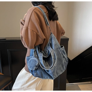 Detail of a large washed denim tote bag with a matching small round hanging coin purse accessory