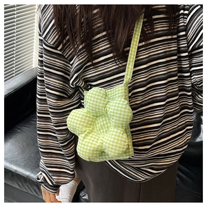 Détail du sac bandoulière en forme de fleur à carreaux verts et blancs avec sangle