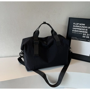 Close-up of waterproof black travel duffel bag with reinforced handles and metal buckles