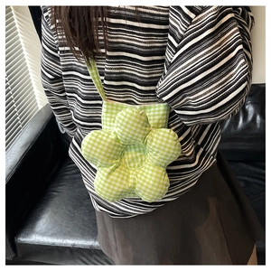 Détail du sac bandoulière en forme de fleur avec un motif à carreaux vert et blanc