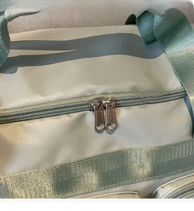 Dettaglio delle doppie cerniere in metallo e cinghie in nylon della borsa da viaggio