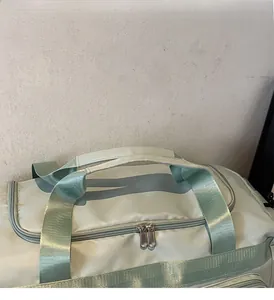 Dettaglio dei manici rinforzati e delle cuciture su una borsa da viaggio sportiva verde menta