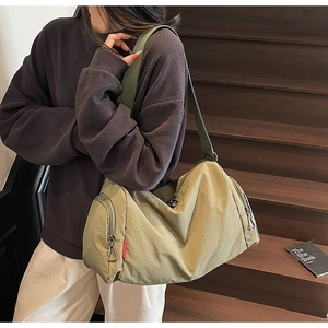 Detail view of large olive green gym bag with zippered side pockets and adjustable strap