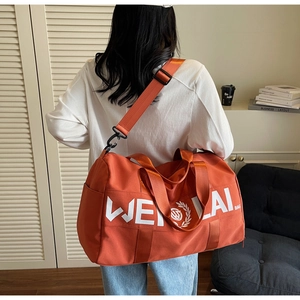 Detail of orange sports duffel bag with wide adjustable shoulder strap on model