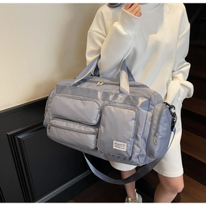 Dettaglio della borsa da viaggio grigio-viola con tasche multiple e tracolla regolabile