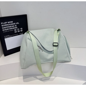 Detailansicht der großen mintgrünen Reisetasche mit breitem Gurt und mehreren Taschen