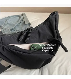 Detail of black nylon half-moon crossbody bag showing large capacity and inner zip pocket