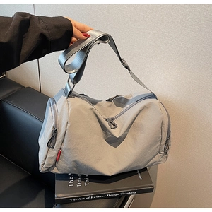 Detail view of the silver-grey waterproof nylon fitness bag with wide adjustable shoulder strap