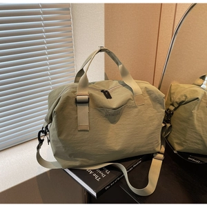 Detail of green travel bag showing nylon texture and adjustable shoulder strap