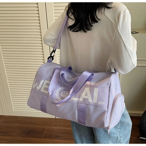 Rear view of a model carrying the lavender fitness bag showing size and shoulder strap