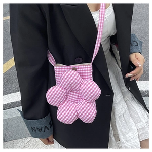 Détail du sac bandoulière en forme de fleur à carreaux roses avec un bouton central