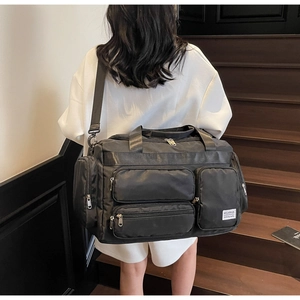 Vista posteriore di un modello con la borsa da viaggio nera impermeabile e multitasche