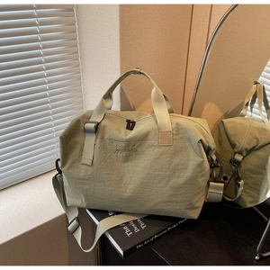 Detail of sage green travel bag with Hellaibag logo and adjustable shoulder strap