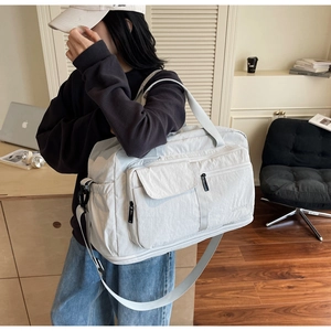 Detail of a beige waterproof nylon travel bag with large capacity and multi-pocket design