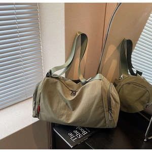Detail view of military green gym bag with waterproof nylon texture and side zipper pockets