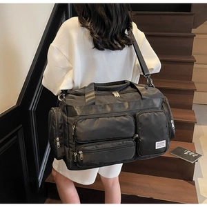 Dettaglio borsa da viaggio nera capiente con tasche multiple e tracolla regolabile