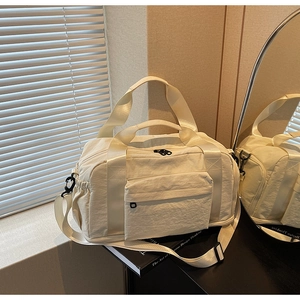 Detail of off-white large canvas travel bag with adjustable strap and front pocket