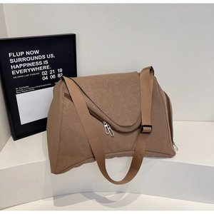 Detail einer braunen strukturierten Reisetasche mit Dreiecksklappe und Silberreißverschluss