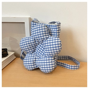 Gros plan du sac à carreaux bleu et blanc avec une grande décoration de fleur 3D