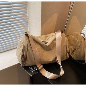 Detail of khaki nylon travel bag with side zipper pocket and wide adjustable strap