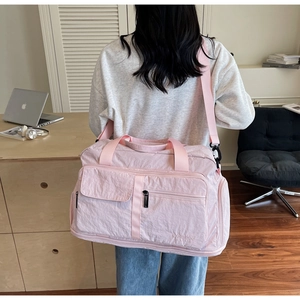 Detail of pink large travel bag with water-resistant nylon and adjustable shoulder strap