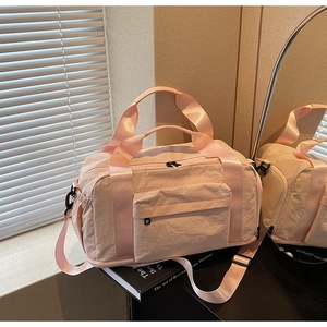 Close-up of pink large capacity travel bag with handles and adjustable shoulder strap