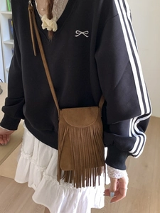 Brown faux suede crossbody bag with long fringes and bohemian vintage style strap