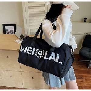 Detail of a large black gym bag featuring white WEI LAI BAG logo and durable handles