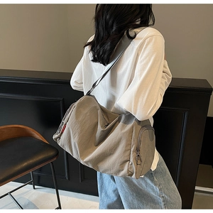 Detail view of large gray waterproof canvas bag with side zipper pocket and metal D-ring