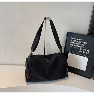 Close-up of high-density black nylon sports bag with silver zippers and red side tag