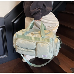 Dettaglio borsa da viaggio verde menta con tasche multiple con zip e tracolla