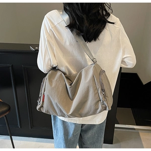 Deep grey canvas crossbody bag with wide strap shown on model for daily commuting