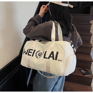 Rear view of a model carrying a white large-capacity sports travel duffel bag on stairs