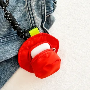 Close-up of red hat-shaped mini pouch showing capacity for wireless earphone storage