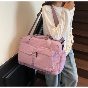 Detail of purple waterproof travel bag with adjustable strap and multiple storage pockets