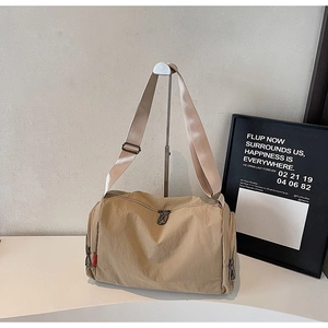 Detail view of khaki sports duffel bag with durable nylon fabric and adjustable wide strap