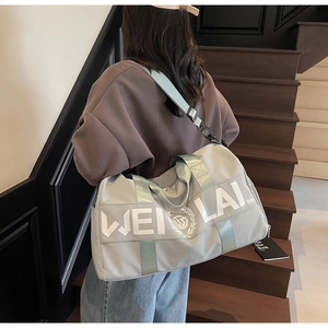 Detailed view of Morandi green gym bag with adjustable strap on wooden stairs